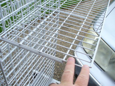 Rolling white metal spinner rack with hooks and baskets