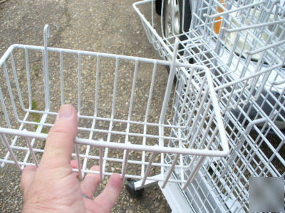 Rolling white metal spinner rack with hooks and baskets