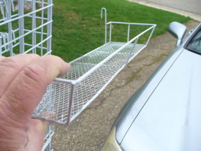 Rolling white metal spinner rack with hooks and baskets