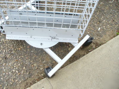 Rolling white metal spinner rack with hooks and baskets