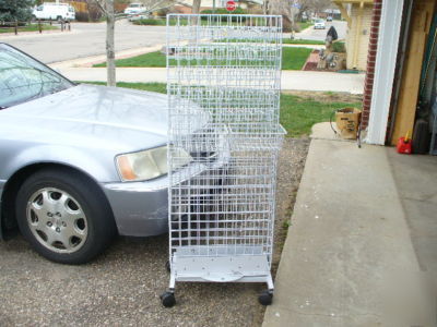 Rolling white metal spinner rack with hooks and baskets